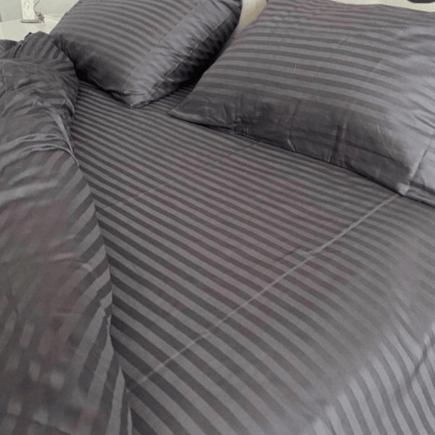 Posteljina DM-GRY od damast pamuka u sivoj boji na krevetu