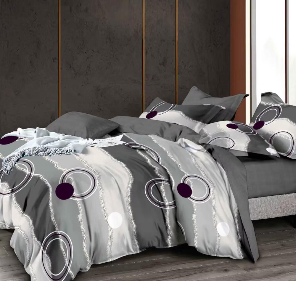 Posteljina od satenskog pamuka u sivim i belim tonovima sa modernim kružnim dezenom na bračnom krevetu